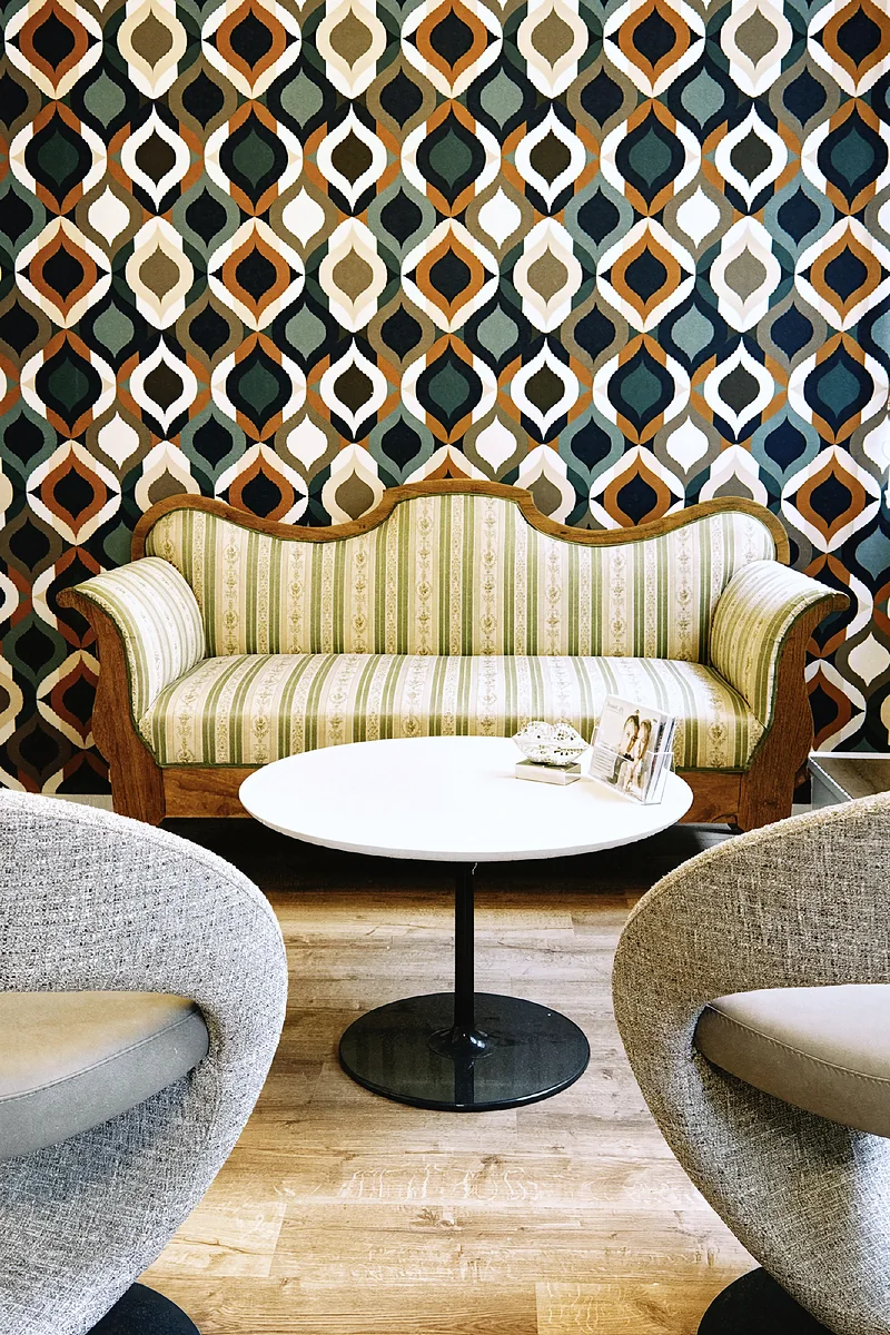 Biedermeier-Sofa vor der Ornamenttapete im Wartebereich